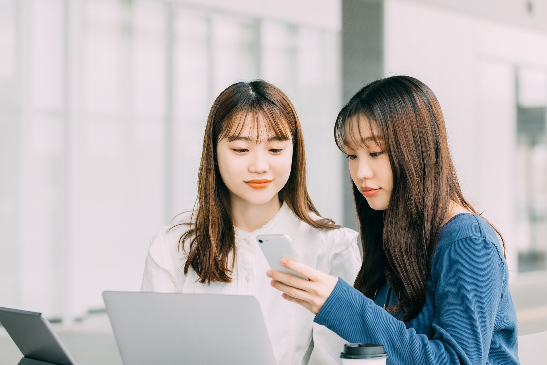 スマホやパソコンで調べる女性