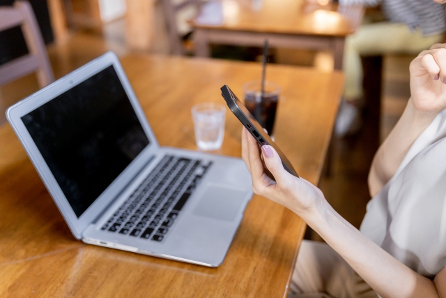 スマホで調べ物をしている女性の手